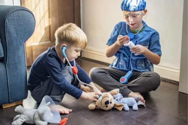 two kids are playing veterinarian pretend play toy