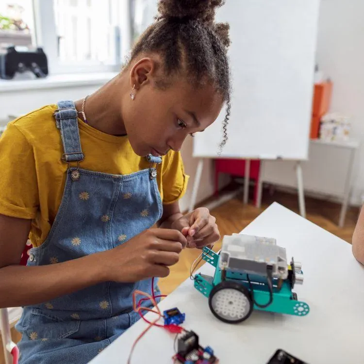 a girl is playing robotic kits